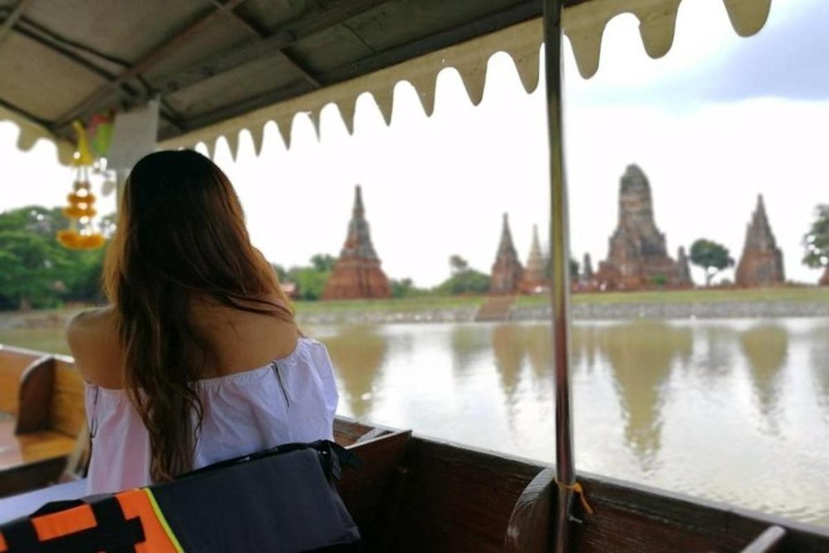 een vrouw die op een boot zit en uitkijkt over een rivier