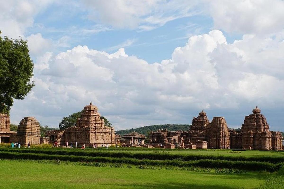 a group of stone temples in a green field
