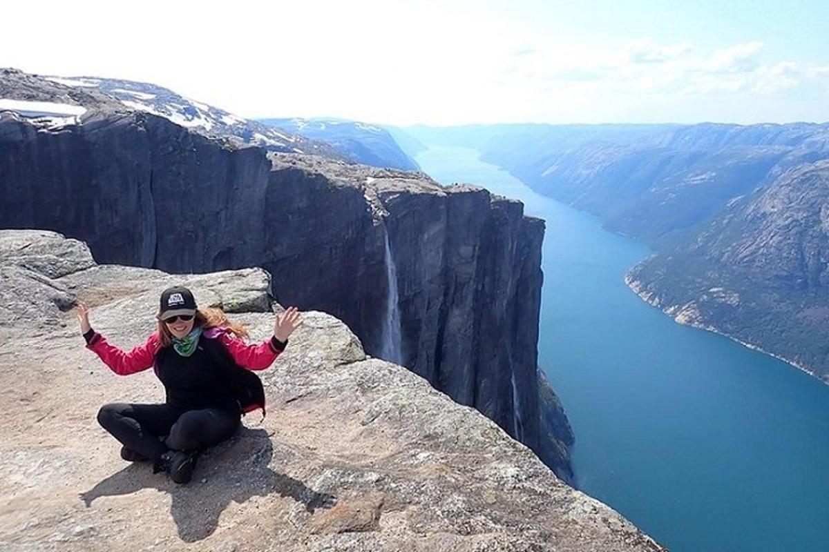 a woman is sitting on the edge of a mountain