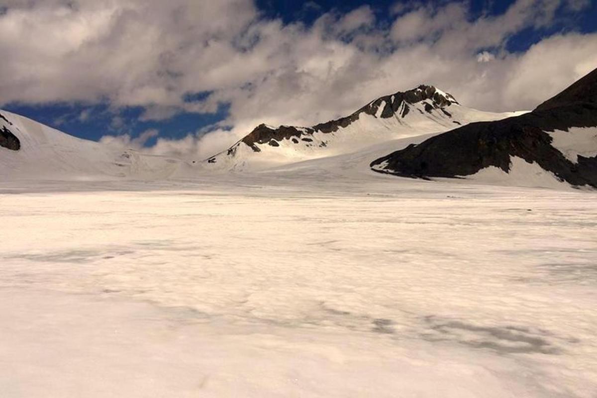 a snow covered mountain range with mountains in the background