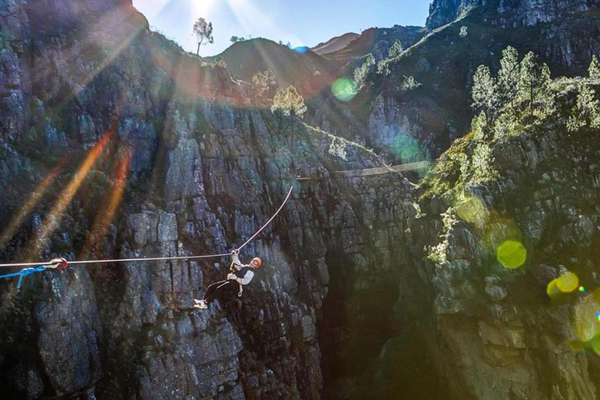 un uomo su una teleferica sopra una parete di montagna