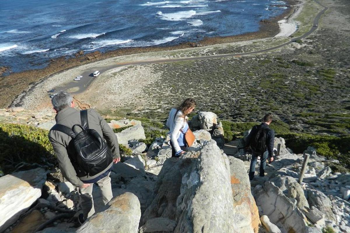 um grupo de pessoas em pé nas rochas perto do oceano