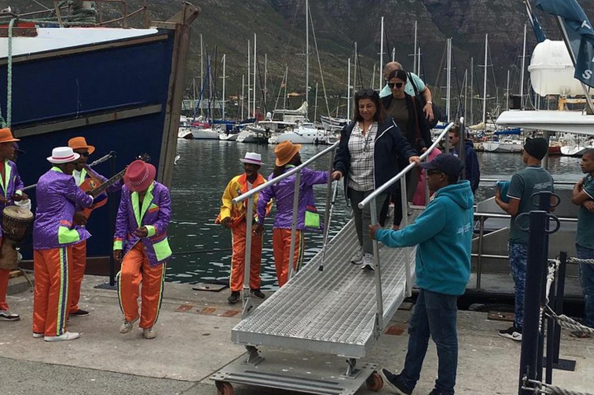 a group of people standing on a dock with boats