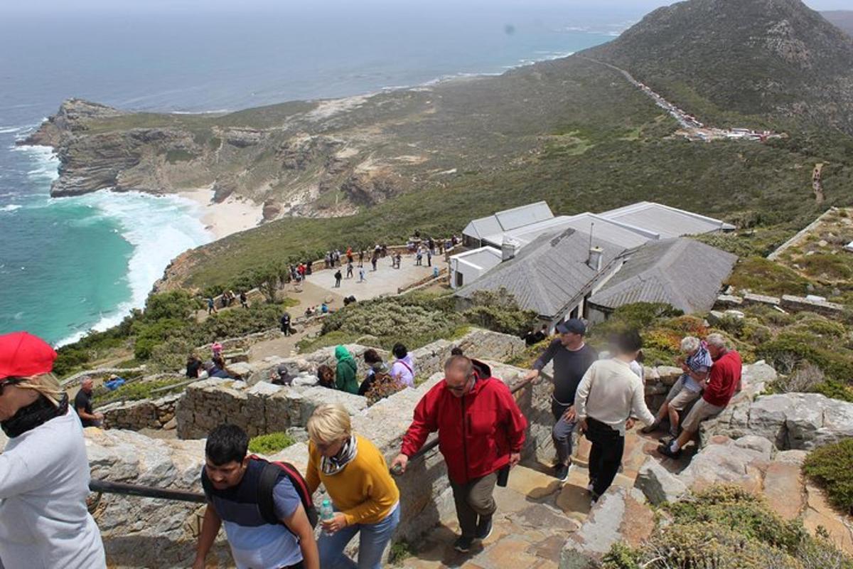 un gruppo di persone che camminano sulle rocce vicino all'oceano