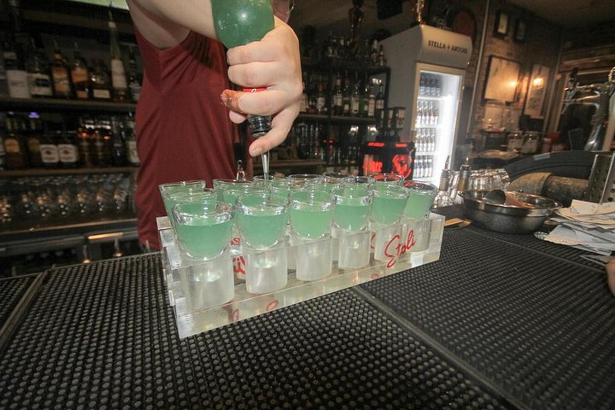 Egy személy zöld folyadékot önt egy pohárba