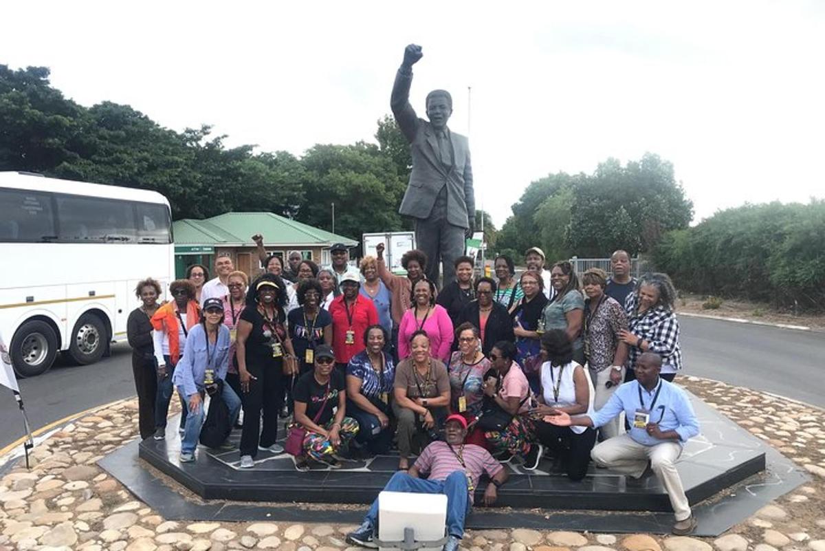a group of people posing in front of a statue