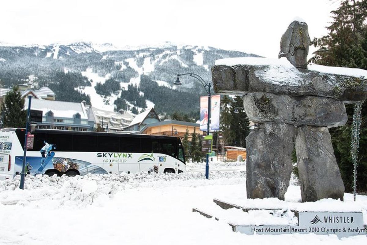 un autobus è parcheggiato accanto a una statua nella neve