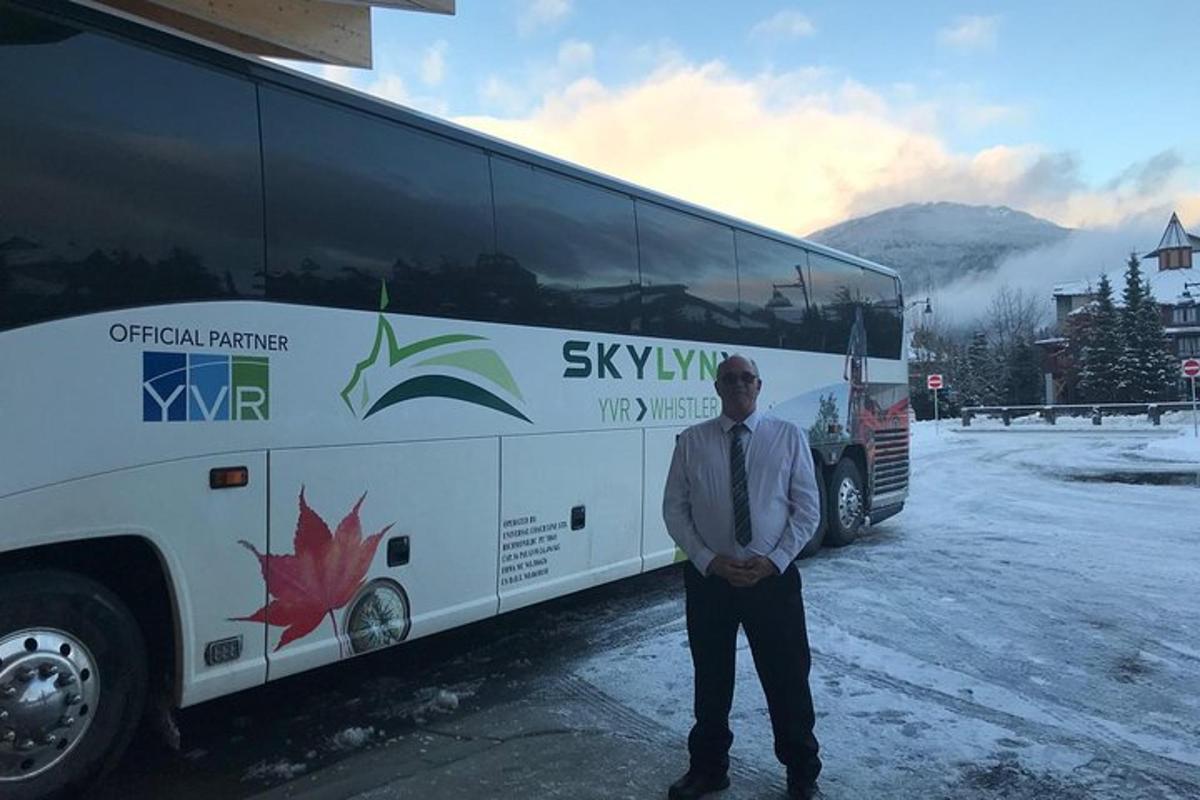 un uomo in piedi davanti a un autobus