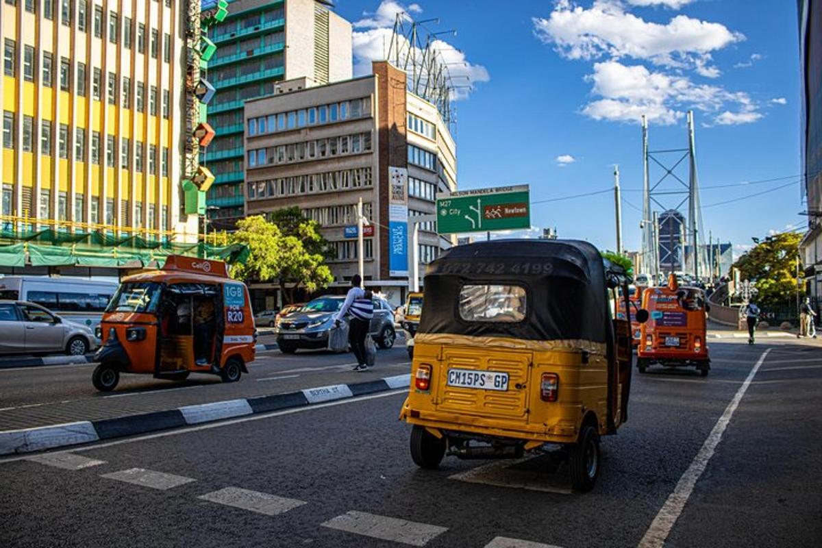 um pequeno veículo amarelo dirigindo por uma rua da cidade
