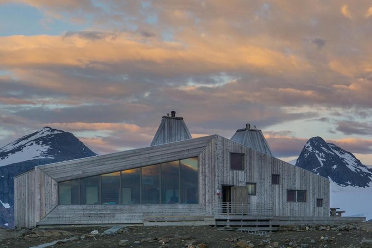 a house on a hill with mountains in the background