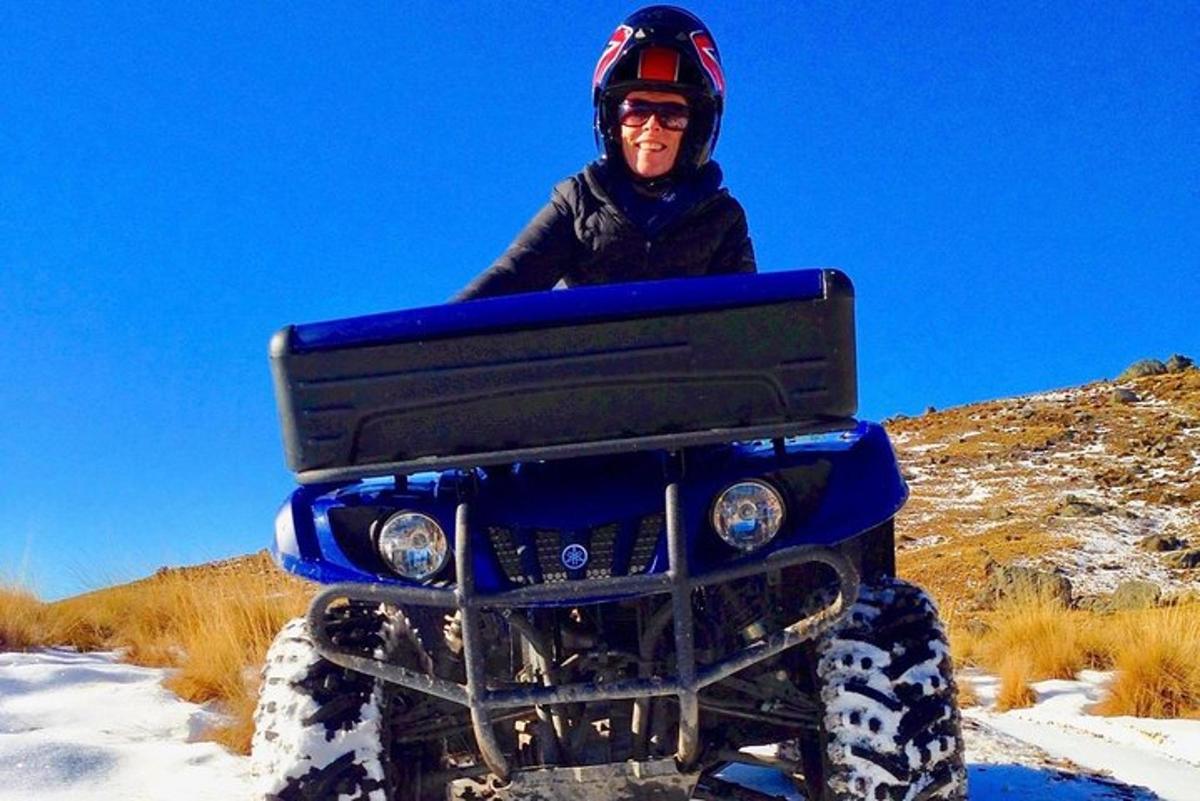 Una persona sentada en la parte trasera de un vehículo todo terreno azul en la nieve.