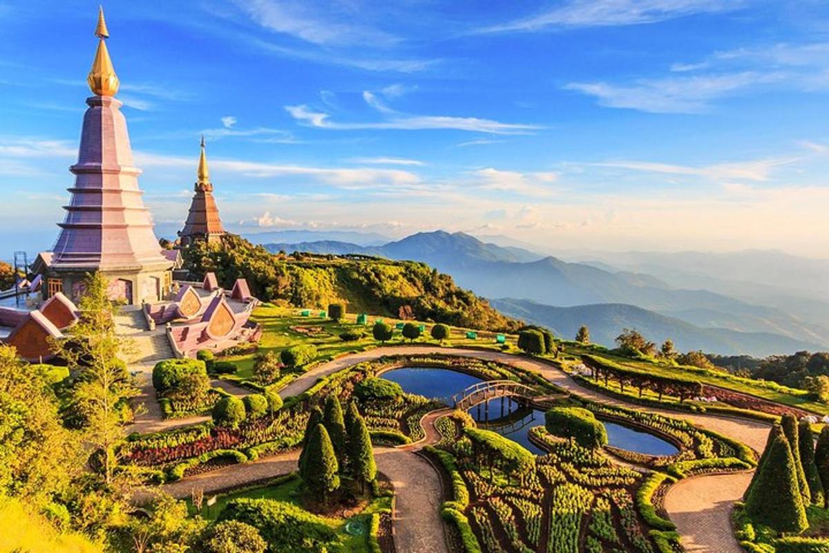 a view of a garden and a temple on a hill