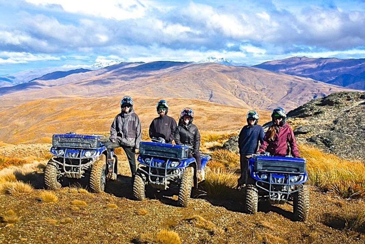 Un grupo de personas sentadas en vehículos todo terreno en una montaña.