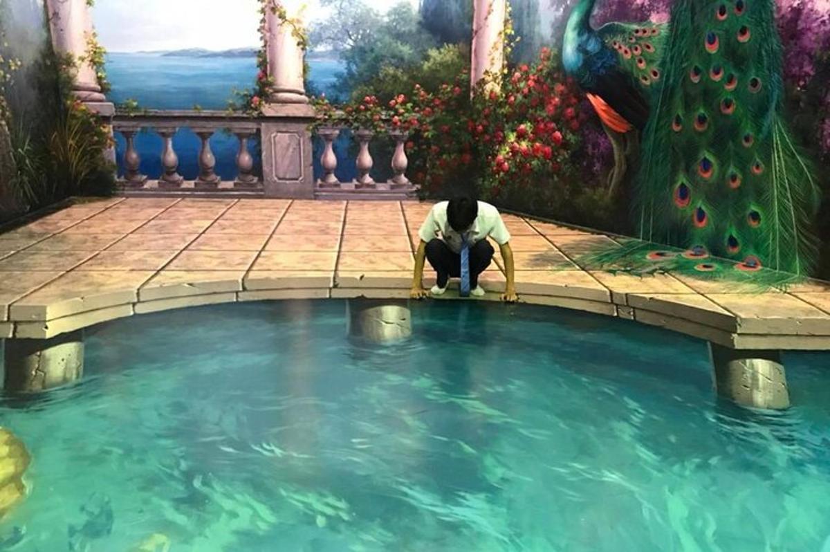 a cat kneeling in front of a pool of water