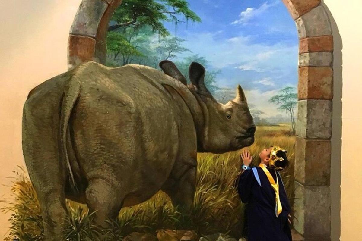 a man standing next to a statue of a rhino