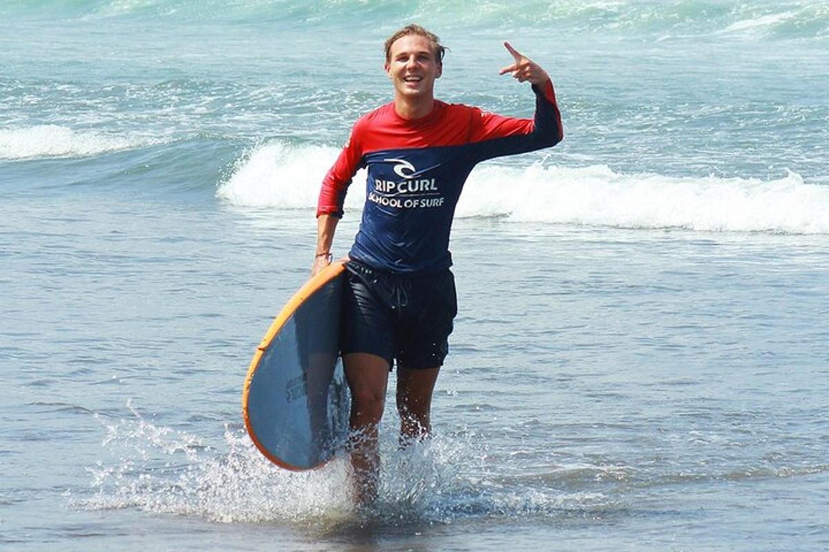 a man standing in the ocean holding a surfboard