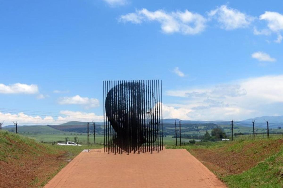 Una gran escultura negra en un camino de tierra
