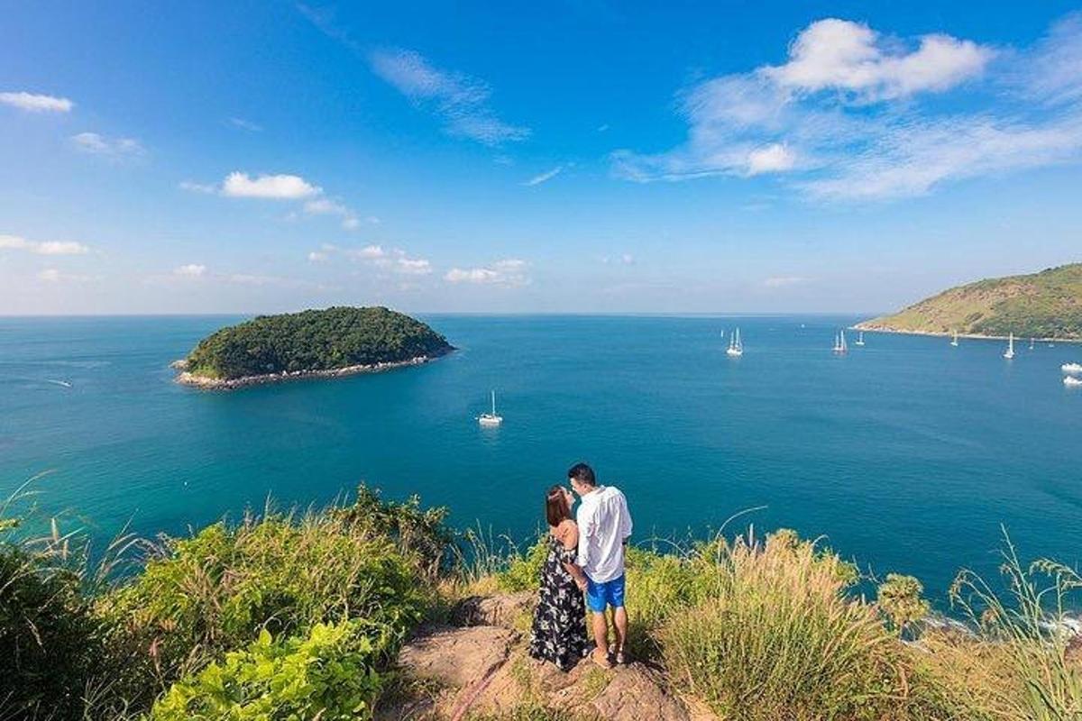 muž a žena stojící na vrcholu kopce s výhledem na oceán
