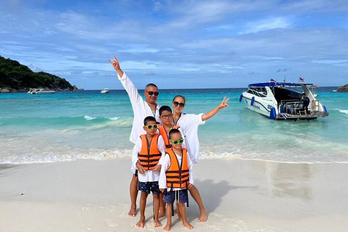 una famiglia in posa sulla spiaggia con una barca