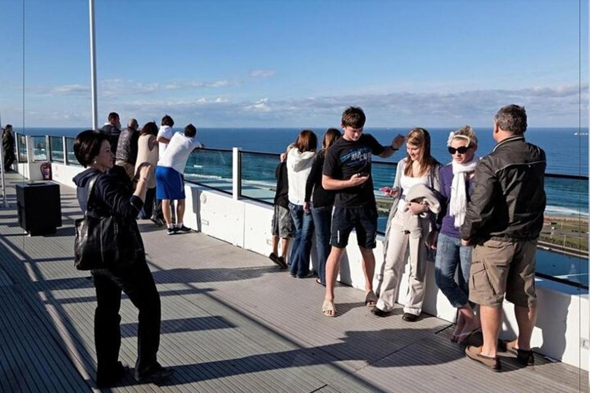 skupina lidí stojících na promenádě u oceánu