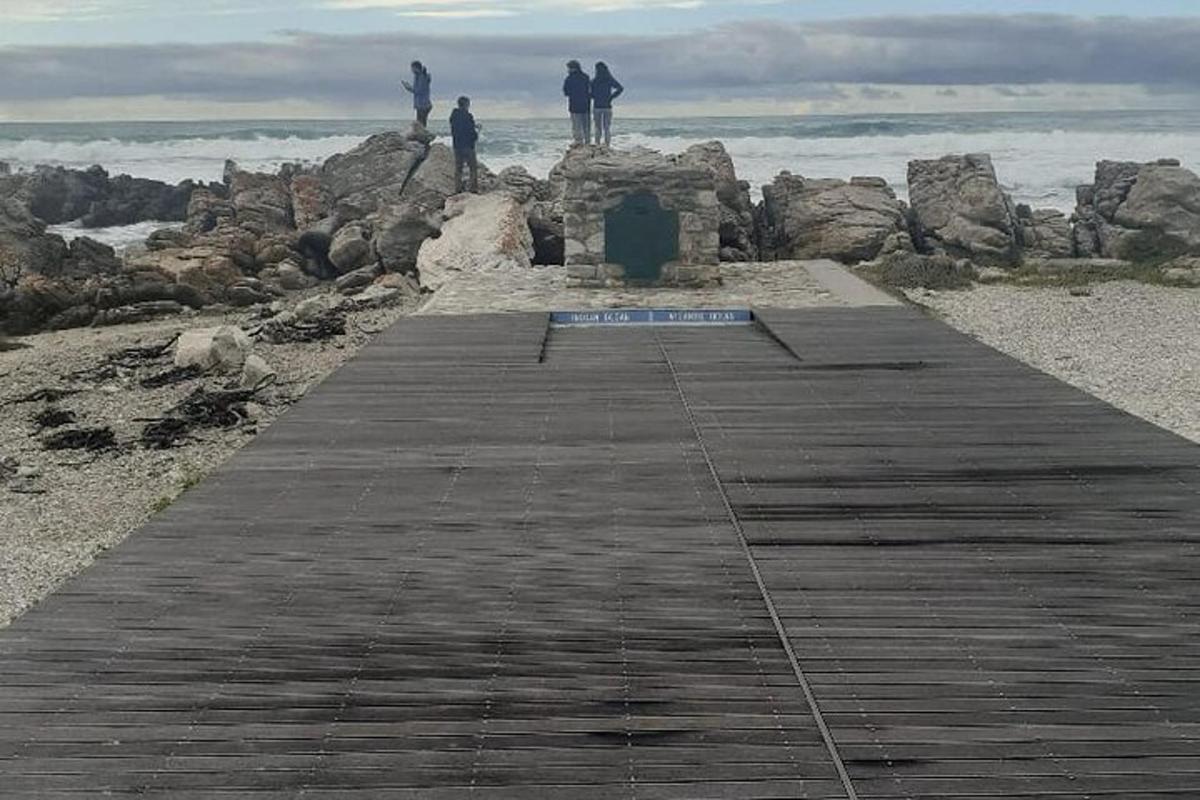 un gruppo di persone in piedi su un molo vicino all'oceano