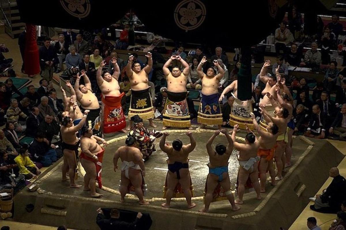 un gruppo di uomini in piedi davanti a un ring di wrestling