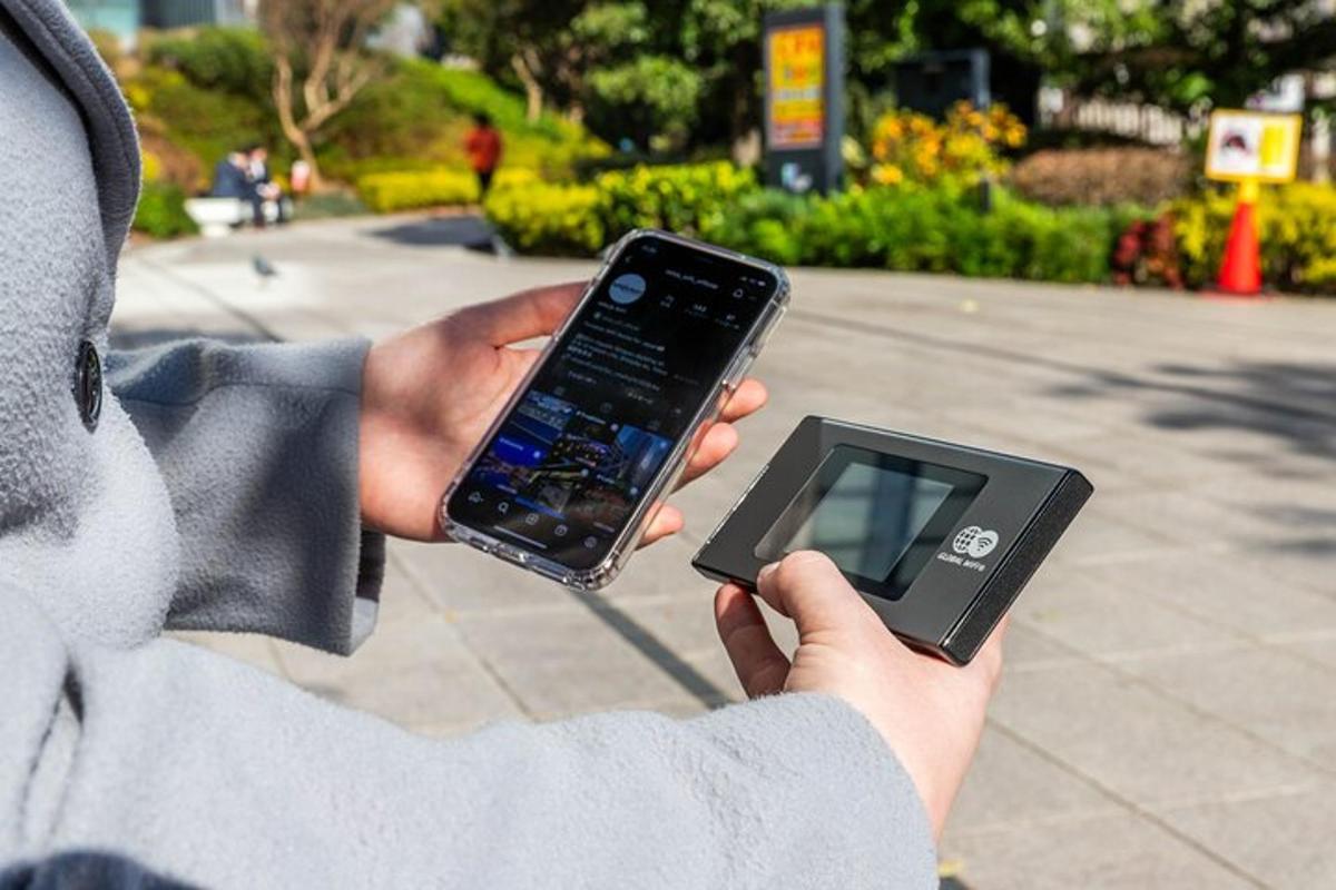 oseba, ki drži mobilni telefon in tablico