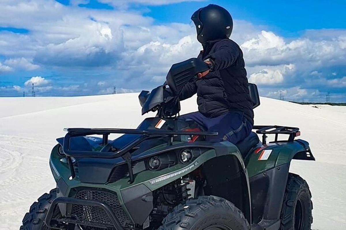 en person sidder på en ATV i sandet