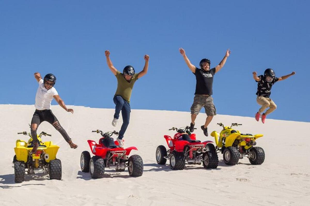 sekumpulan lelaki melompat di pasir dengan atv