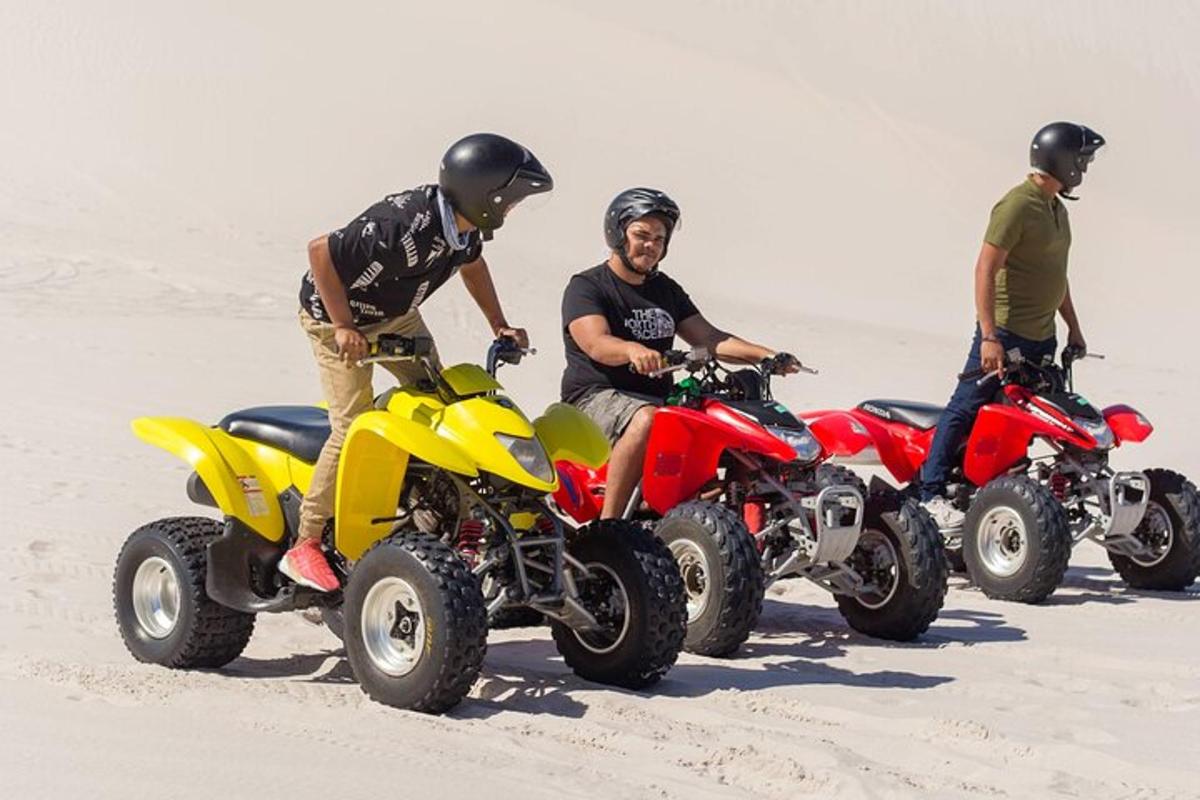 tiga lelaki di atv di pasir di pantai