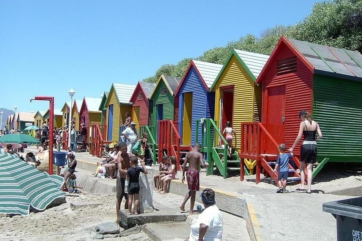 skupina ljudi na plaži s pisanimi kočami na plaži