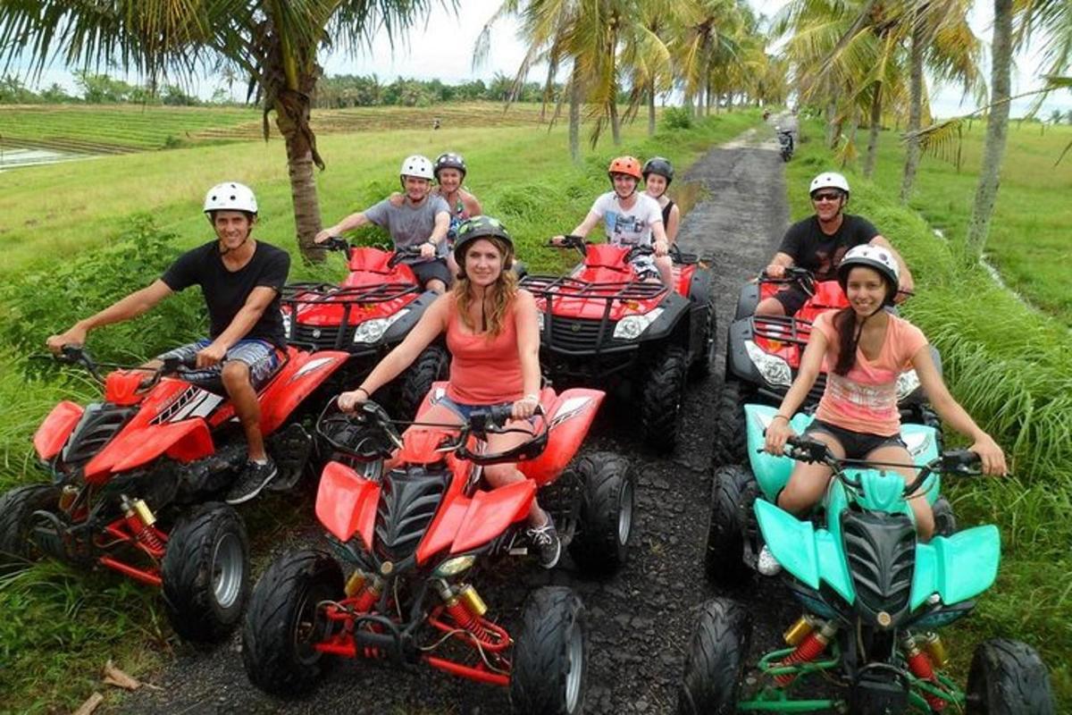 Un grupo de personas conduciendo vehículos todo terreno por un camino de tierra.