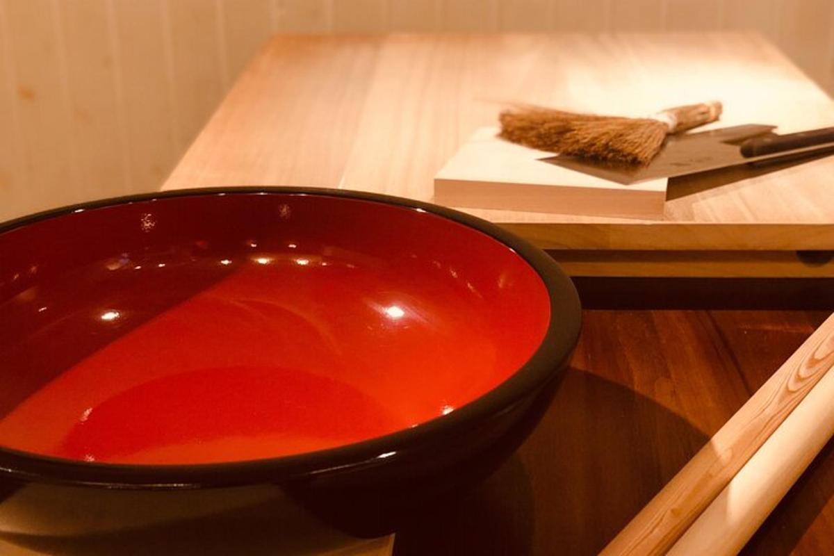 a red bowl sitting on a table with chopsticks