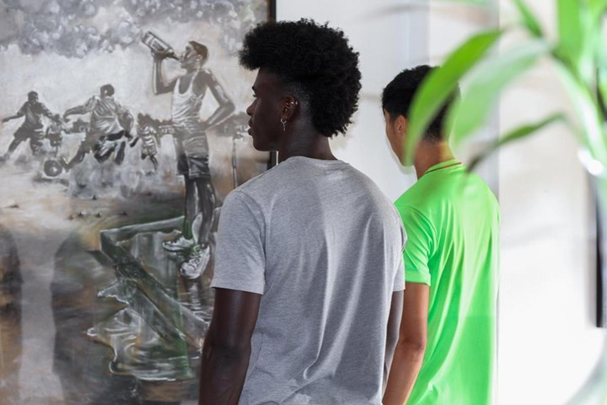 dois jovens em pé em frente a uma pintura