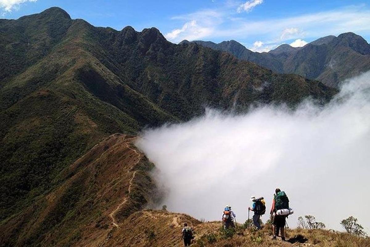 um grupo de pessoas em pé no topo de uma montanha