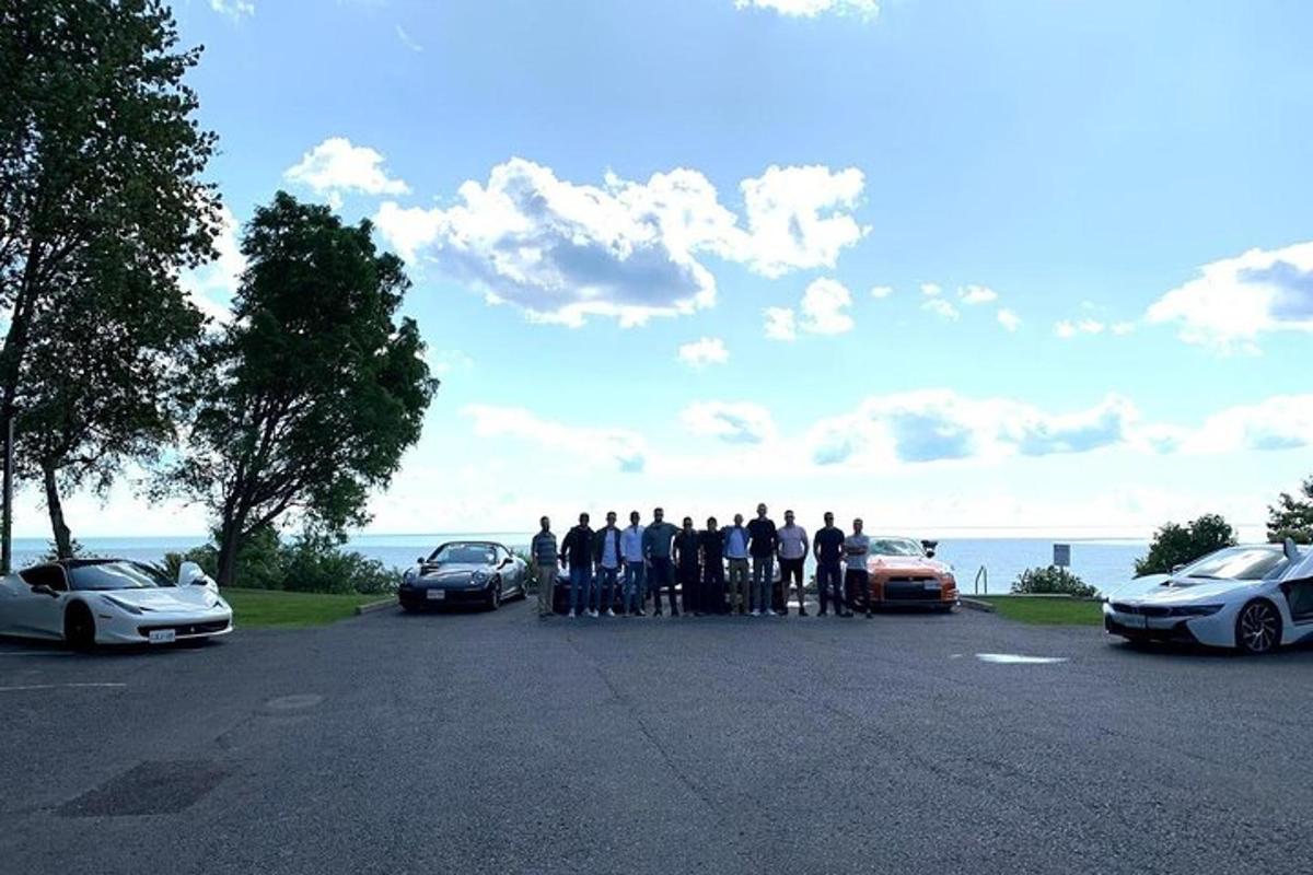 a group of people standing in a parking lot with cars