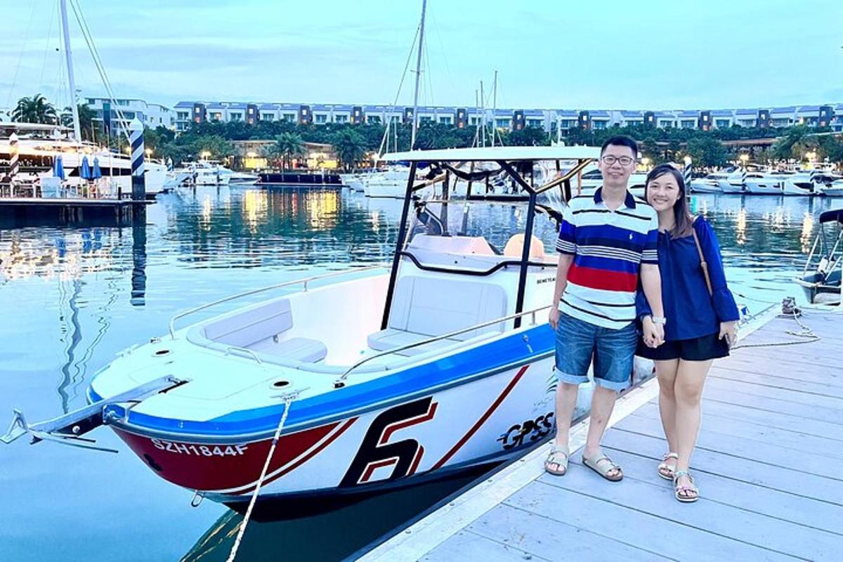 một người đàn ông và một người phụ nữ đứng trên bến tàu cạnh một chiếc thuyền