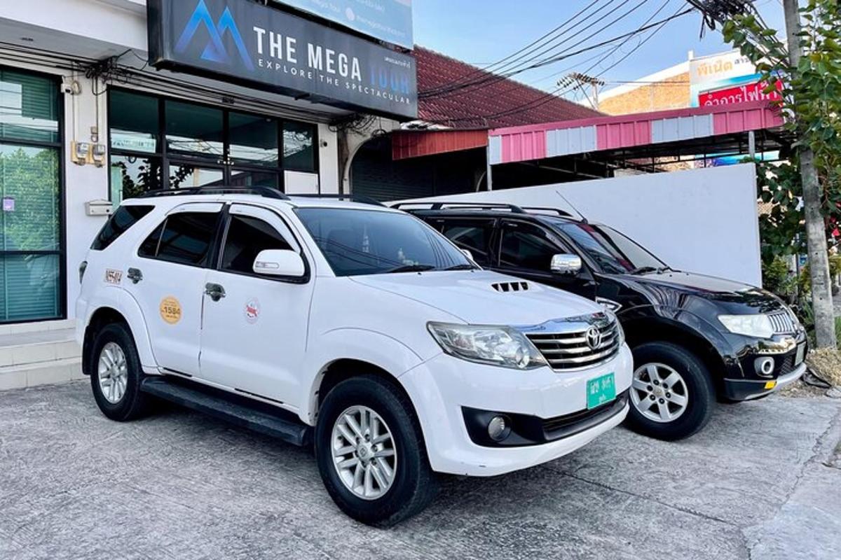 Ένα λευκό SUV και ένα μαύρο αυτοκίνητο παρκαρισμένα μπροστά από ένα κατάστημα