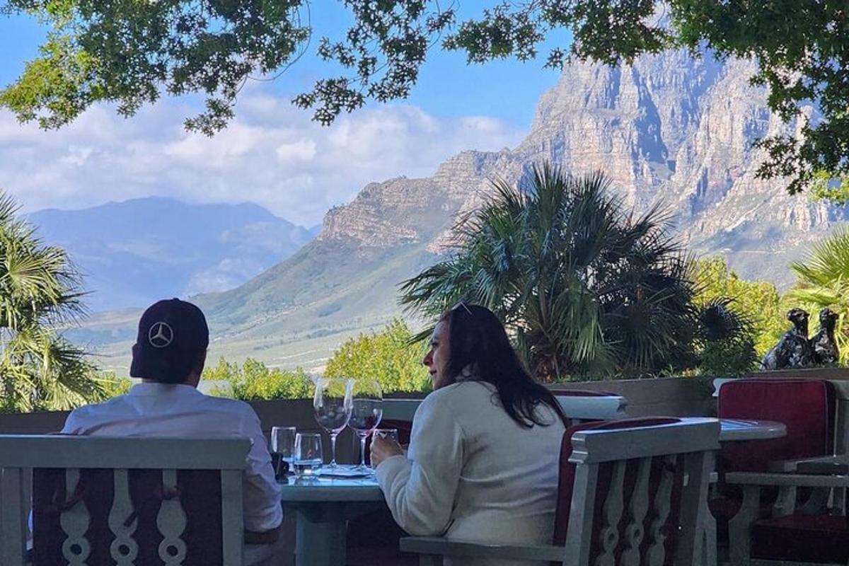 um homem e uma mulher sentados à mesa com taças de vinho