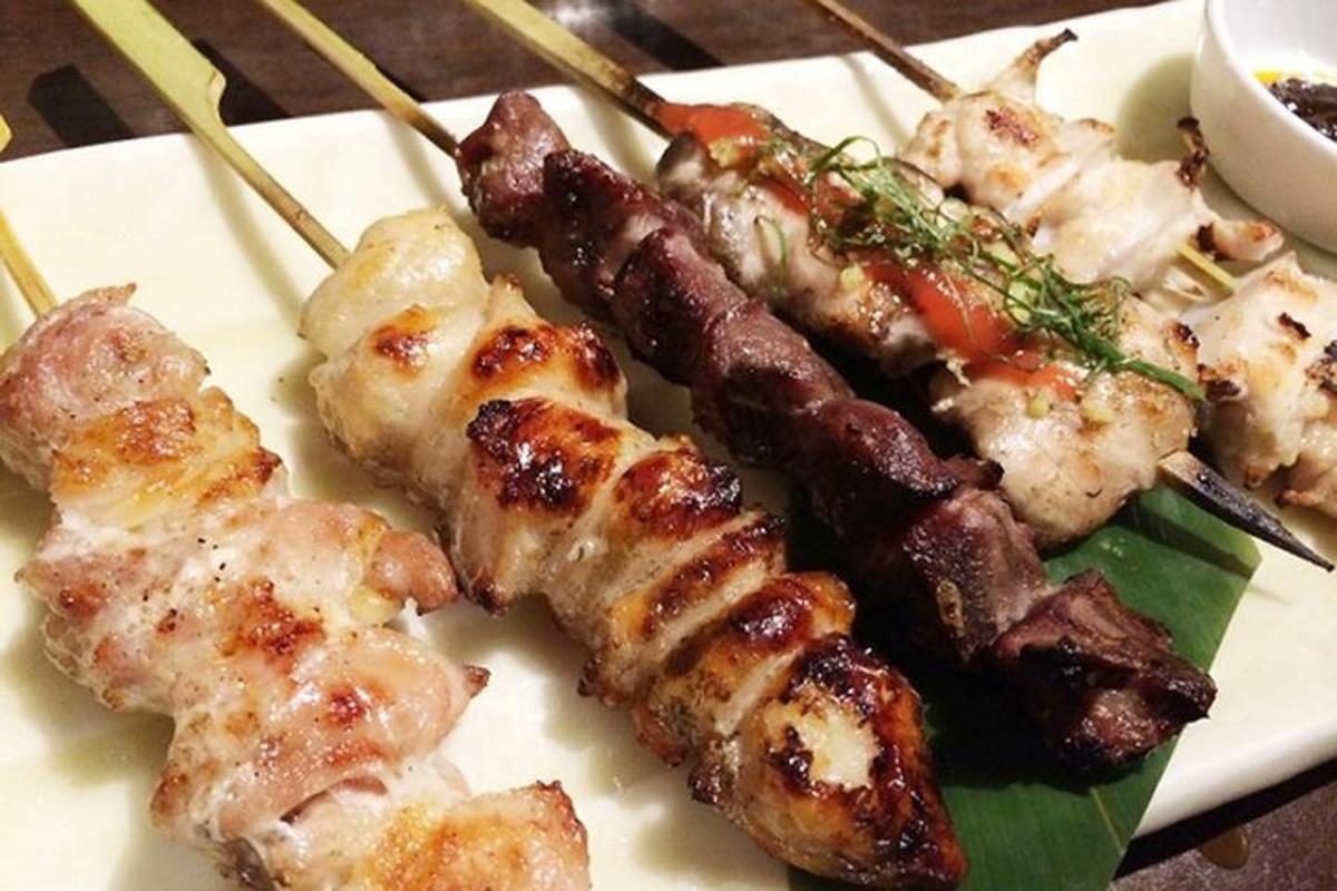 a plate of food with skewers of meat and vegetables