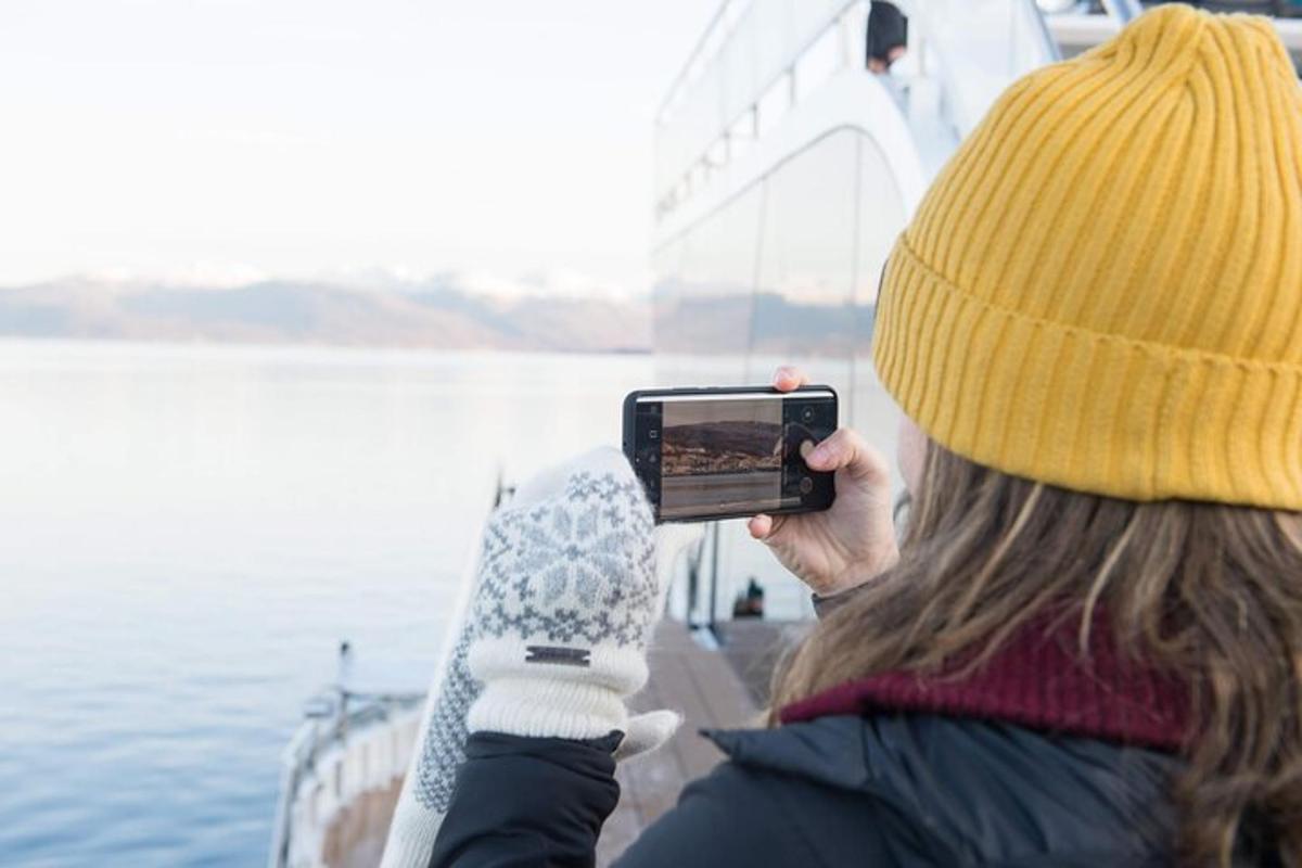 a woman taking a picture of a boat in the water