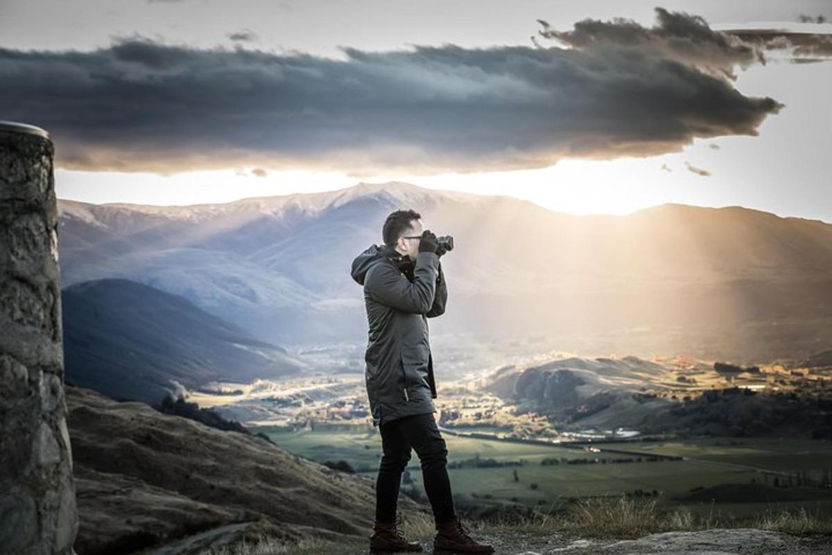muž fotografující horu fotoaparátem