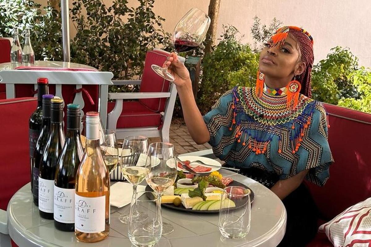a woman sitting at a table with a glass of wine