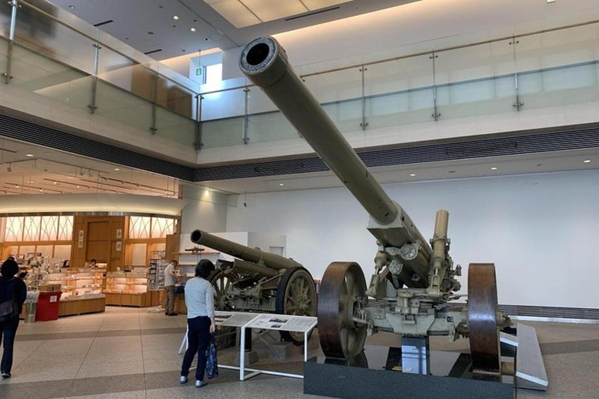 a large cannon in a museum with people looking at it