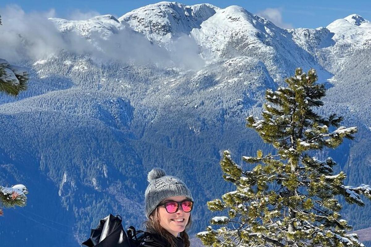 en kvinne som står foran et snødekt fjell