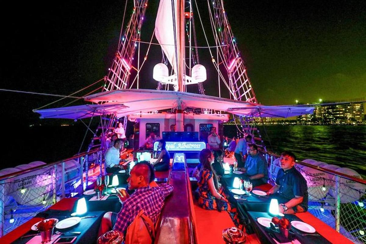 um grupo de pessoas sentadas em um barco à noite