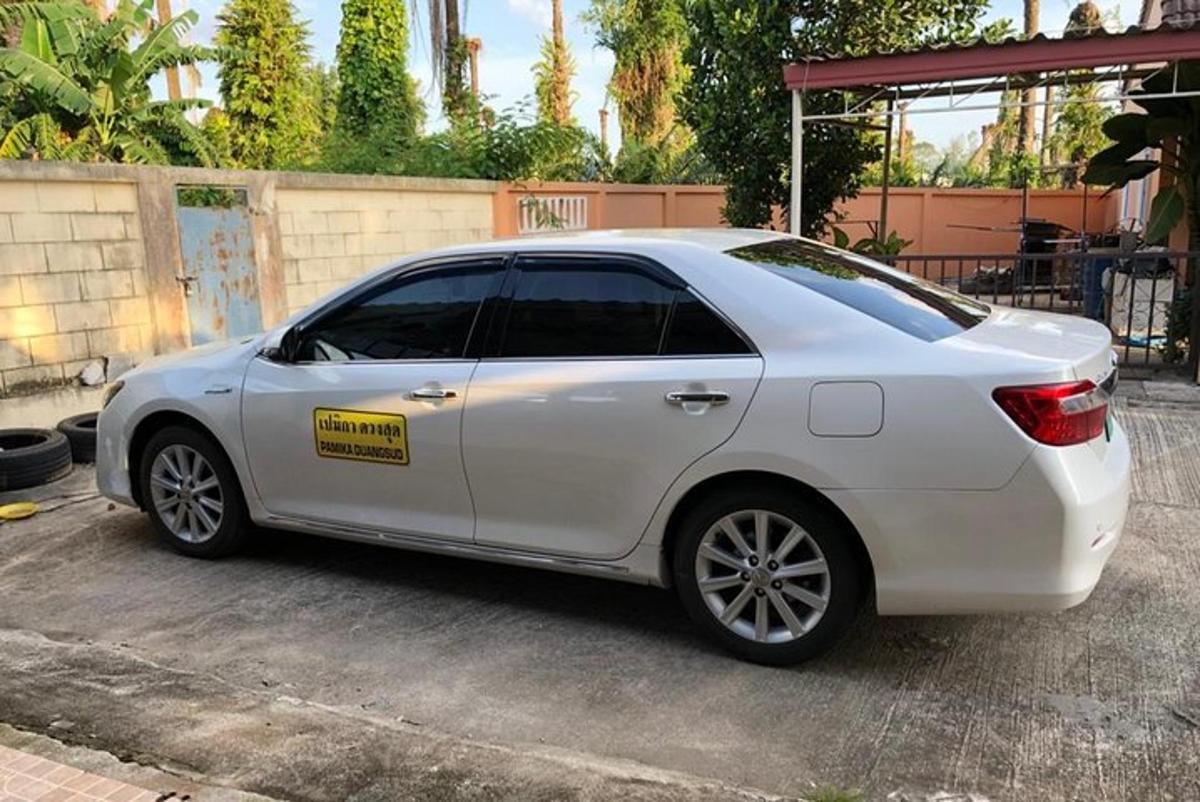 bílé auto zaparkované na parkovišti