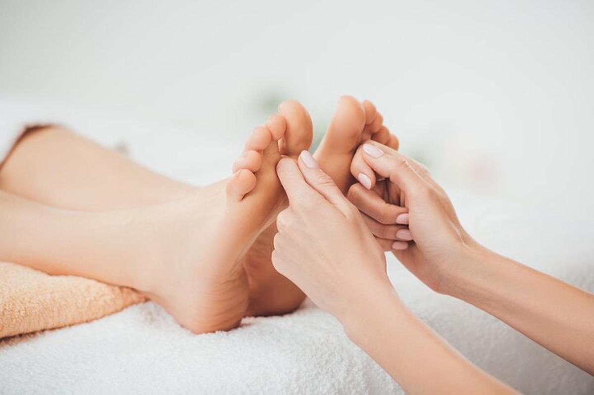 a woman holding her feet together on a bed