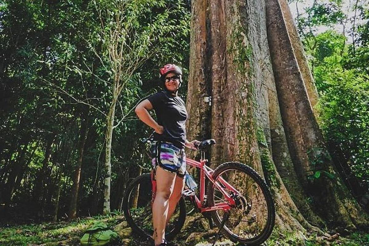 un uomo in piedi accanto a una bicicletta accanto a un albero
