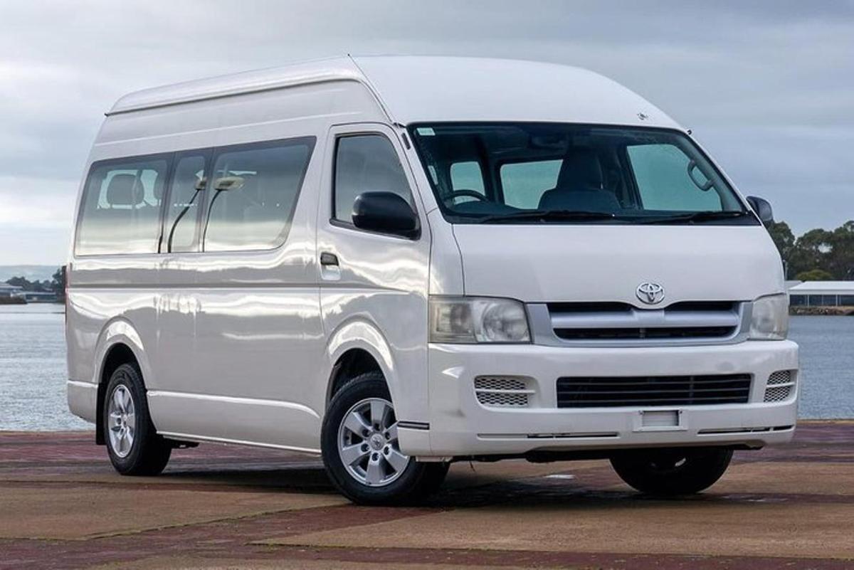 a white van parked next to a body of water